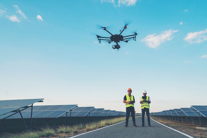 Kiwa inspectors performing on-site drone inspection of solar panels on a solar farm using a drone