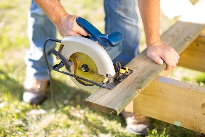 Worker who is sawing