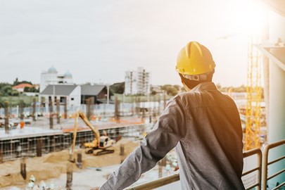 Man in helmet looking over construction site